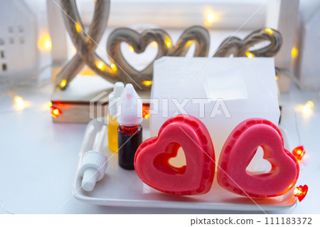 Handmade homemade soap in the shape of hearts for a Valentine's Day gift to your beloved. Perfumes and dyes, soap base on the table Handmade homemade soap in the shape of hearts for a Valentine's Day gift to your beloved. Perfumes and dyes, soap base on the table 111183372