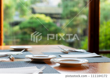 Restaurant with a view of the greenery in the garden, table setting 111184172