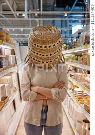 Depressed woman customer standing with wicker basket on head 111184409