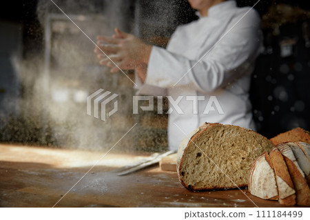 Female chef hands clapping in cloud of powdery flour over table 111184499
