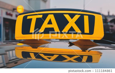 Lit taxi sign on roof of taxi car in the city Lit taxi sign on roof of taxi car in the city 111184861