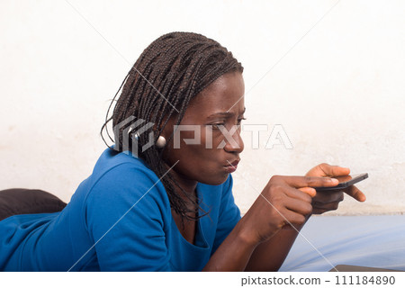 Beautiful young woman using mobile phone plays games 111184890