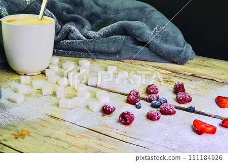 Cup of coffee, sugar cubes, blueberries and strawberries on wooden background. Winter or Valentines day concept 111184926