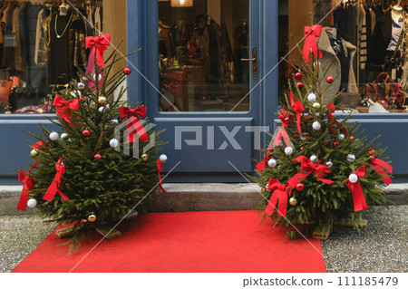 The store window is decorated with Christmas trees. The store window is decorated with Christmas trees. 111185479