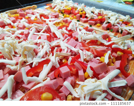 cooking delicious pizza with sausage, tomatoes and cheese at home close-up cooking delicious pizza with sausage, tomatoes and cheese at home close-up 111185637