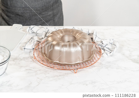 The freshly baked Carrot Bundt Cake is left to cool on the kitchen counter, filling the air with delightful aromas. 111186228