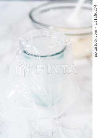 Transferring homemade royal icing into the piping bags for decorating sugar cookies. Transferring homemade royal icing into the piping bags for decorating sugar cookies. 111186274
