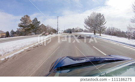 Post-winter storm, the drive on a suburban road provides a peaceful journey. The picturesque scene, with snow adorning the landscape, adds to the tranquility of the experience. Post-winter storm, the drive on a suburban road provides a peaceful journey. The picturesque scene, with snow adorning the landscape, adds to the tranquility of the experience. 111186275