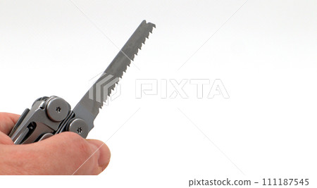 On a white background, a man's hand holds a steel multi-tool or pocket knife with an open saw. Compact and portable multi-tasking multitool with many tools. EDC concept. A tool for daily practice On a white background, a man's hand holds a steel multi-tool or pocket knife with an open saw. Compact and portable multi-tasking multitool with many tools. EDC concept. A tool for daily practice 111187545