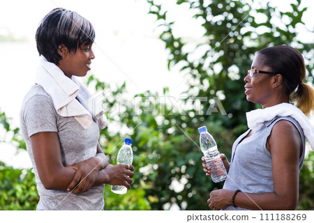 Two young women having a break after jogging. Two young women having a break after jogging. 111188269