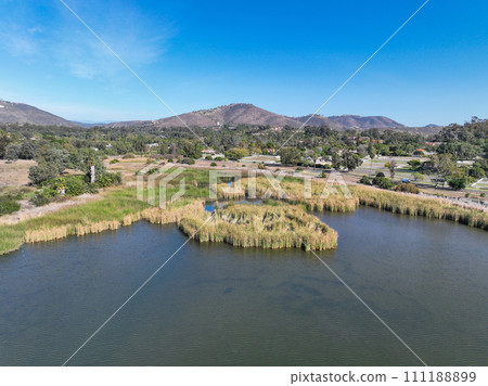 Aerial view over water reservoir and a large dam that holds water. Rancho Santa Fe in San Diego Aerial view over water reservoir and a large dam that holds water. Rancho Santa Fe in San Diego 111188899