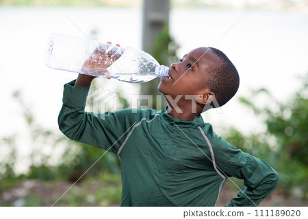 child drinking bottled water in nature 111189020