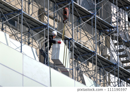 Large-scale demolition work: A steeplejack worker installing soundproof panels on temporary scaffolding 111190397