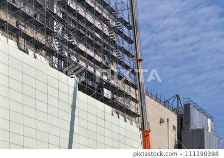 Large-scale demolition work: A steeplejack worker installing soundproof panels on temporary scaffolding 111190398