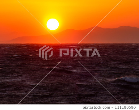 Dynamic sunset view of the Pacific Ocean seen from Nojimazaki with strong winds and rough waves 111190590