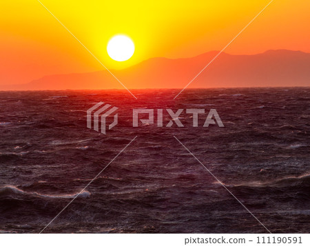 Dynamic sunset view of the Pacific Ocean seen from Nojimazaki with strong winds and rough waves 111190591