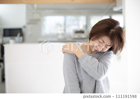 A middle-aged Japanese woman suffering from stiff shoulders A middle-aged Japanese woman suffering from stiff shoulders 111191598