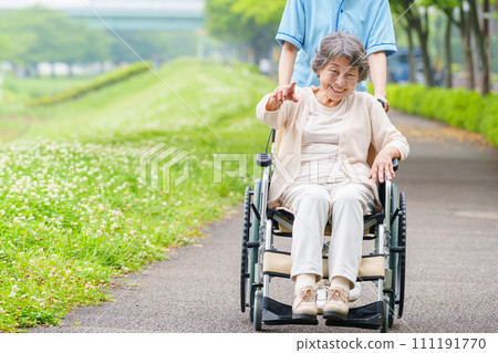 Senior woman and carer in wheelchair 111191770