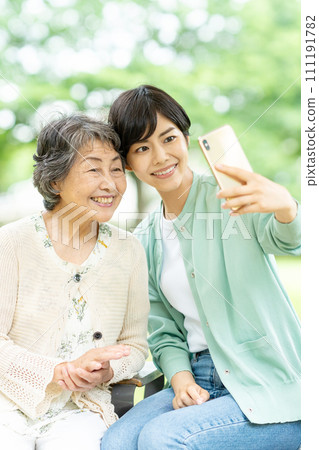 老年女性和年輕女性用智慧型手機自拍 111191782