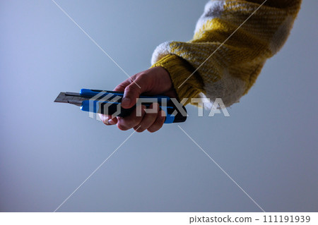 A woman's hand clutching a cutter 111191939