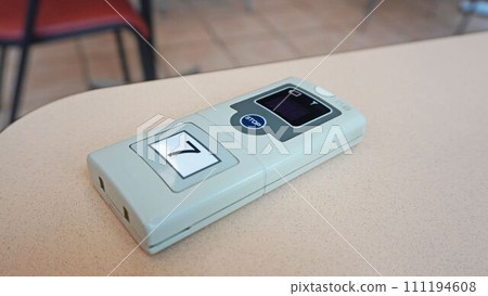 呼叫蜂鳴器放置在美食廣場的桌子上 呼叫蜂鳴器放置在美食廣場的桌子上 111194608