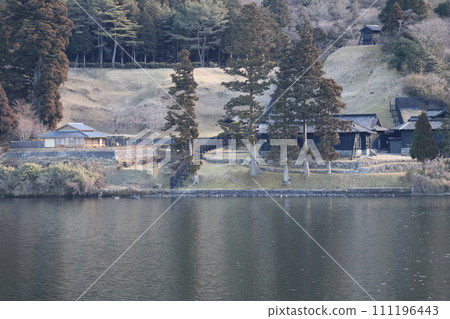 Landscape of a forest of trees and buildings on the lakeshore and a quiet lake seen from the top of a sightseeing boat Landscape of a forest of trees and buildings on the lakeshore and a quiet lake seen from the top of a sightseeing boat 111196443