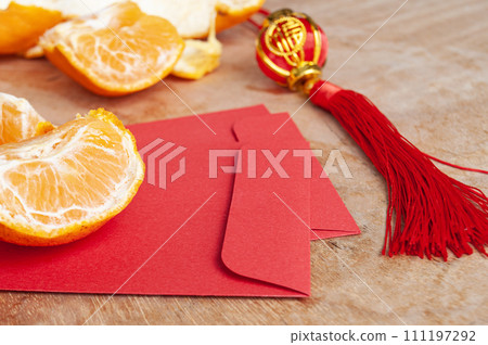 Peal Mandarin oranges and Chinese New Year red envelope. Chinese New Year celebration concept 111197292