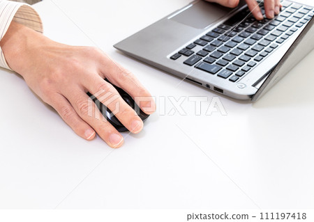 A man working with a laptop and mouse A man working with a laptop and mouse 111197418