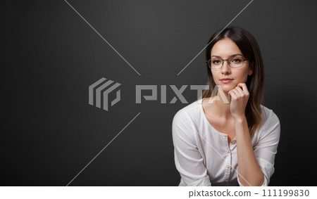 Young woman isolated on dark gray background. minded woman touch hand chin. think thoughts about life problems. isolated over dark gray background Young woman isolated on dark gray background. minded woman touch hand chin. think thoughts about life problems. isolated over dark gray background 111199830