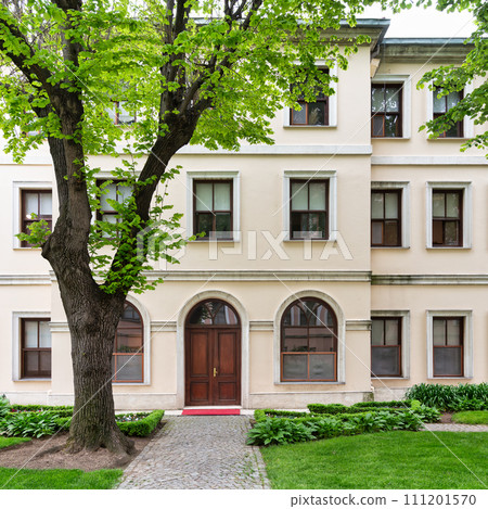 Old building in Dolmabahce Palace, Istanbul, Turkey, shines in courtyard sunlight, softened by a towering tree Old building in Dolmabahce Palace, Istanbul, Turkey, shines in courtyard sunlight, softened by a towering tree 111201570