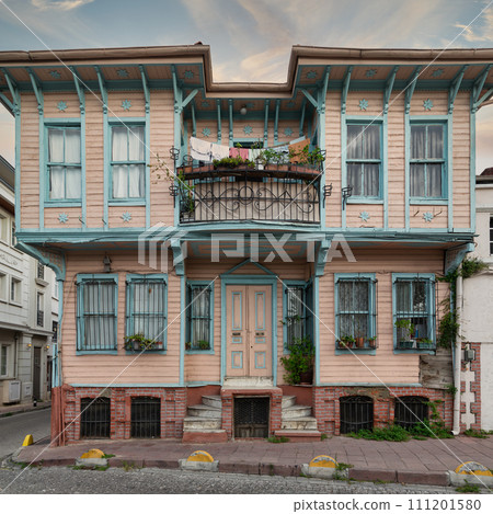 Colorful wooden house in Istanbul's Fatih district. Painted pink and blue with flower-adorned balconies 111201580