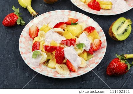 Fruit juicy salad with yogurt on a plate. 111202331