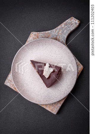 Piece of delicious sweet chocolate cake with sponge cake and cream Piece of delicious sweet chocolate cake with sponge cake and cream 111202403