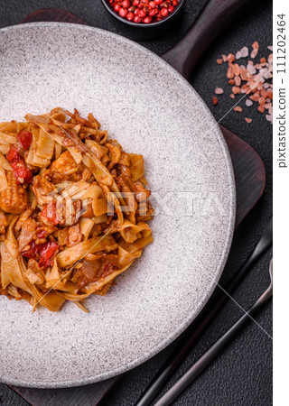 Delicious asian udon dish with vegetables, mushrooms, salt and spices 111202464