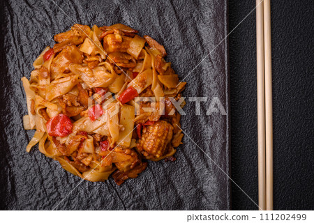Delicious asian udon dish with vegetables, mushrooms, salt and spices 111202499