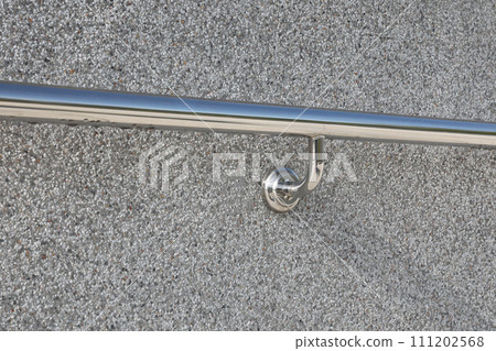 Stainless handrail installed on gray terrazzo  wall. 111202568
