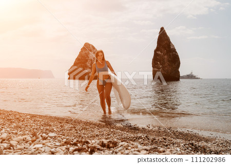 Woman sea sup. Close up portrait of happy young caucasian woman with long hair looking at camera and smiling. Cute woman portrait in bikini posing on sup board in the sea Woman sea sup. Close up portrait of happy young caucasian woman with long hair looking at camera and smiling. Cute woman portrait in bikini posing on sup board in the sea 111202986