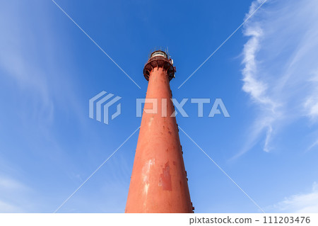 Looking up at the Andenes Lighthouse, its red silhouette contrasts with the soft cloud patterns Looking up at the Andenes Lighthouse, its red silhouette contrasts with the soft cloud patterns 111203476