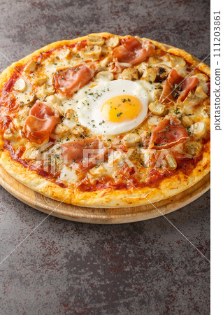 Italian Pizza Bismarck topped with tomato sauce, melted cheese, egg, mushrooms, ham close-up on a wooden board. Vertical Italian Pizza Bismarck topped with tomato sauce, melted cheese, egg, mushrooms, ham close-up on a wooden board. Vertical 111203861
