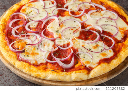 Pizza pugliese is a thin pizza covered with tomato sauce, cheese and a lot of onions close up on a wooden board. Horizontal Pizza pugliese is a thin pizza covered with tomato sauce, cheese and a lot of onions close up on a wooden board. Horizontal 111203882