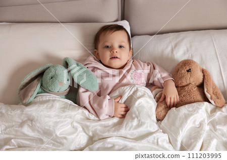 cute little child with fluffy toy bunny in white bed cute little child with fluffy toy bunny in white bed 111203995