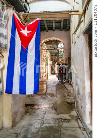 Authentic courtyard of a house on the street of Havana with a cuba flag and a motorcycle 111204078