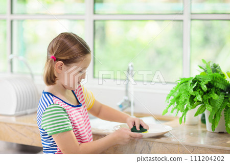Child washing dishes. 111204202
