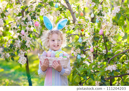 Kids on Easter egg hunt in blooming garden. Kids on Easter egg hunt in blooming garden. 111204203