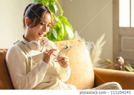 使用智能手機的婦女在沙發 111204245