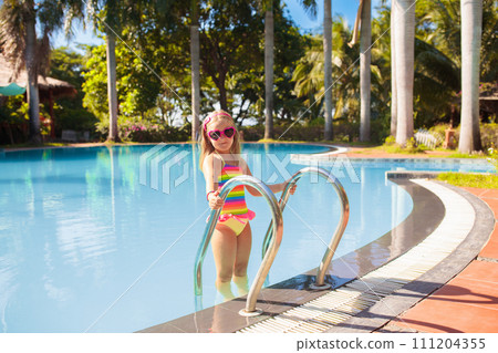 Child in swimming pool with ball. Kids swim. 111204355