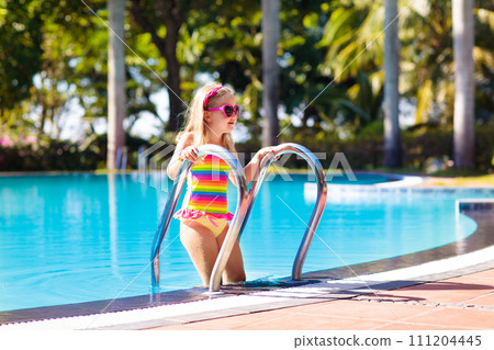 Child in swimming pool with ball. Kids swim. 111204445