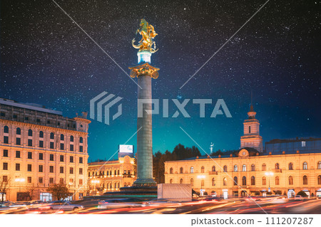 Tbilisi, Georgia, Eurasia. Amazing Bold Bright Blue Starry Sky Gradient Above Liberty Monument Depicting St George Slaying The Dragon And Tbilisi City Hall In Freedom Square In City Center 111207287