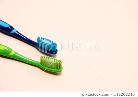 Two toothbrushes on a beige background, copy space for text. Two toothbrushes on a beige background, copy space for text. 111208216