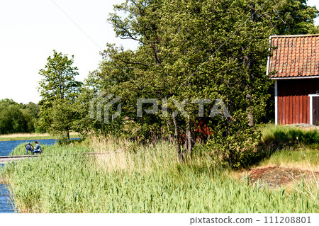 Traditional red small swedish house near lake. Traditional red small swedish house near lake. 111208801